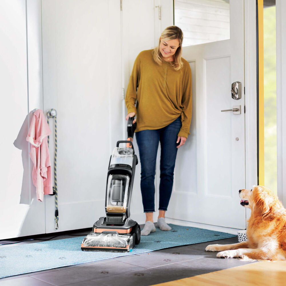 Woman cleaning carpet with a steam cleaner Stock Photo by perfectlab